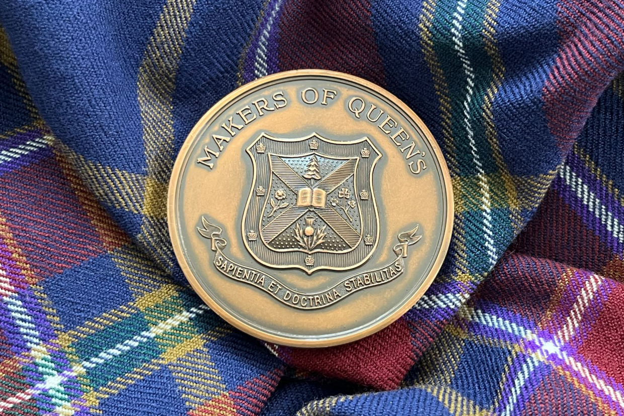 The John B. Stirling Montreal Medal rests on the Queen's University tartan
