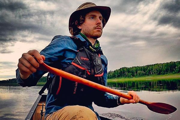 Adam Shoalt paddling a canoe.