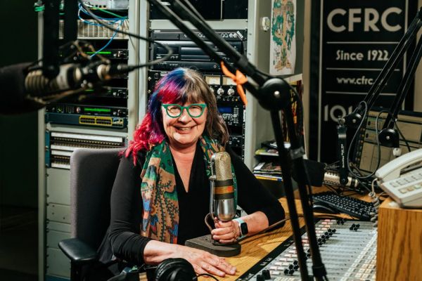 Shelagh Rogers holding a microphone in the CFRC studio