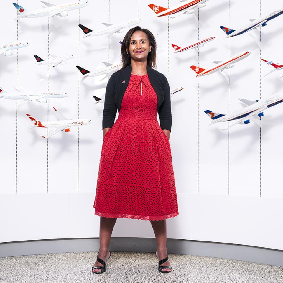 Woman standing in front of a wall holding models of airplanes