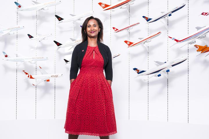 Woman standing in front of a wall holding models of airplanes
