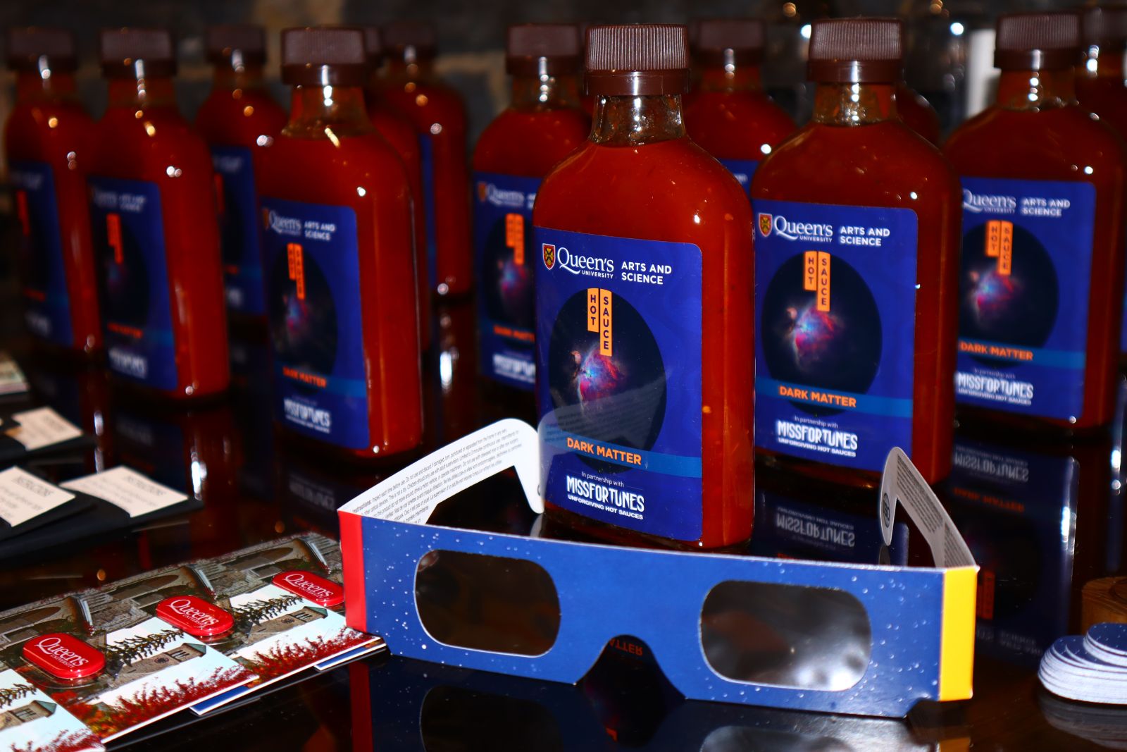 Solar Eclipse Glasses and FAS branded hot sauces titled "Dark Matter"