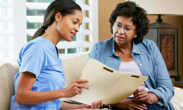 A healthcare professional sharing information in a folder with a client