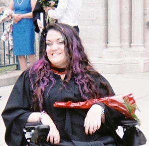A graduate with flowers smiling