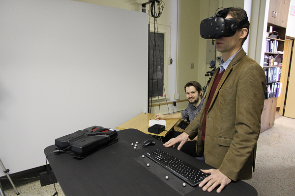 Nikolaus Troje explores virtual reality while PhD candidate Christoph Lenk monitors his progress. (University Communications)