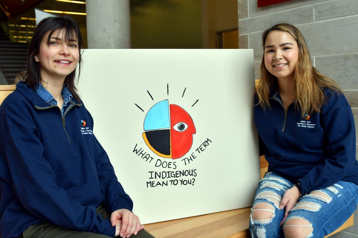 Queen's Native Students' Association member Helena Kita (Artsci'19) and Co-President Sarah Hanson (Artsci'17) help take down the thoughts of the Queen's community as part of Indigenous Awareness Week. (University Communications)
