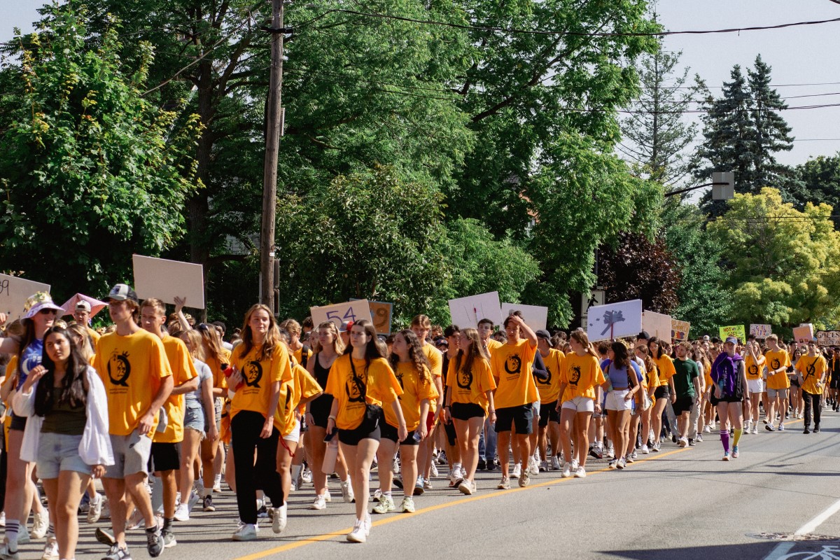 Photograph of Queen's students parading to Richardson Stadium during orienation.