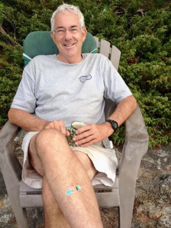 Image of Geoff Smith smiling holding coffee on a deck