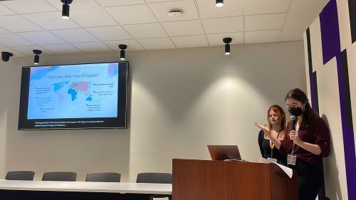 An image of Emily and Rhianna presenting at the I@Q Conference in Stauffer Library.