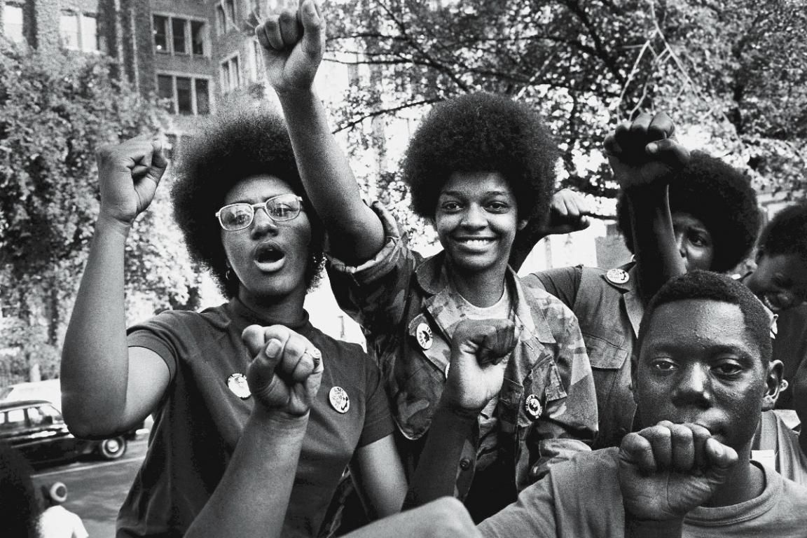 A black and white photograph of black women at an outdoor rally 