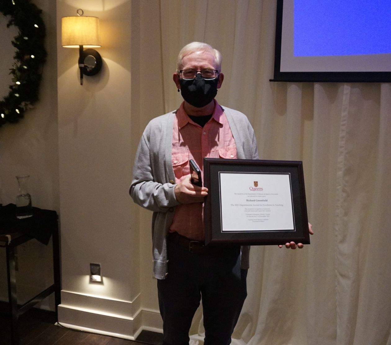 Richard Greenfield holds his Faculty Teaching Award certificate at the University Club