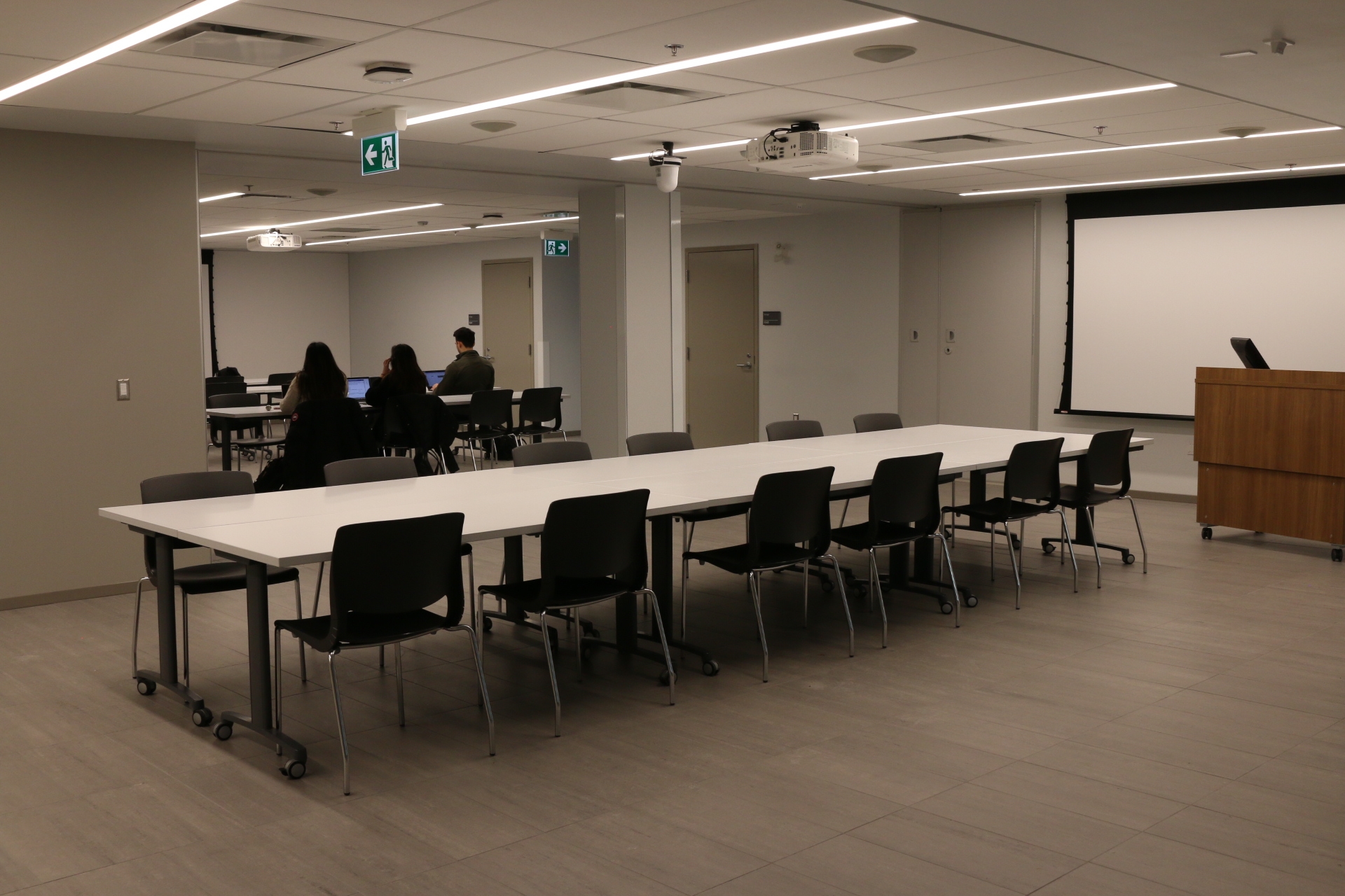 The LinQLab space with tables, chairs, and a projector screen.