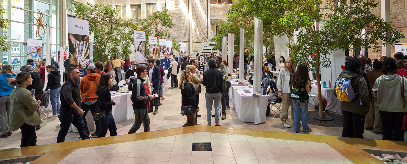 Biosciences complex atrium on open house day with booths for future students to ask questions