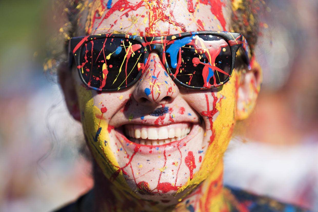 Up close photo of a person covered in tricolour paint