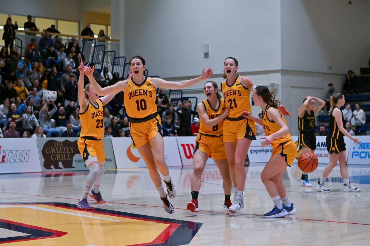 Women's Basketball players in gold uniforms celebrating on court