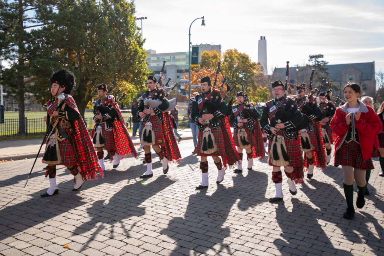 Queen's band members marching on campus.