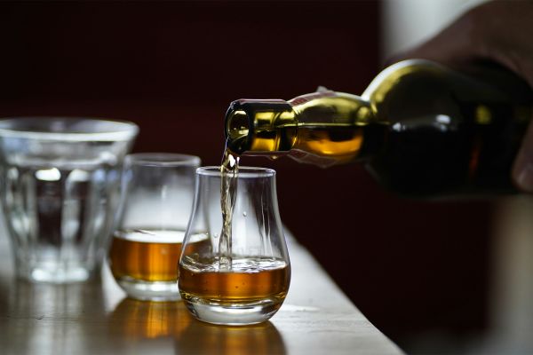 Pouring whiskey into shaped glasses