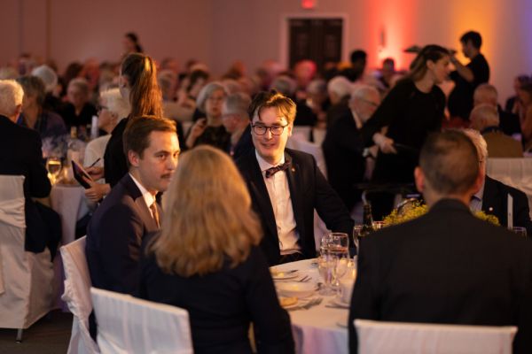 Various people gather for a formal dinner. 