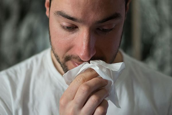 Man wiping his nose