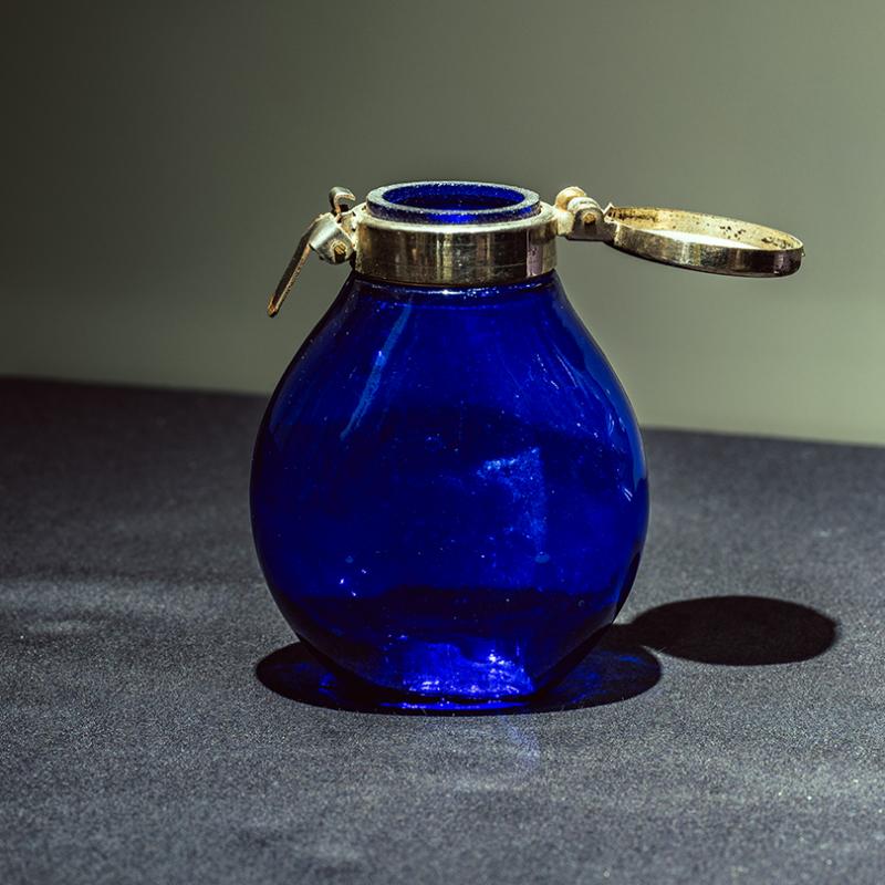 Small flask with a metal lid and clasp
