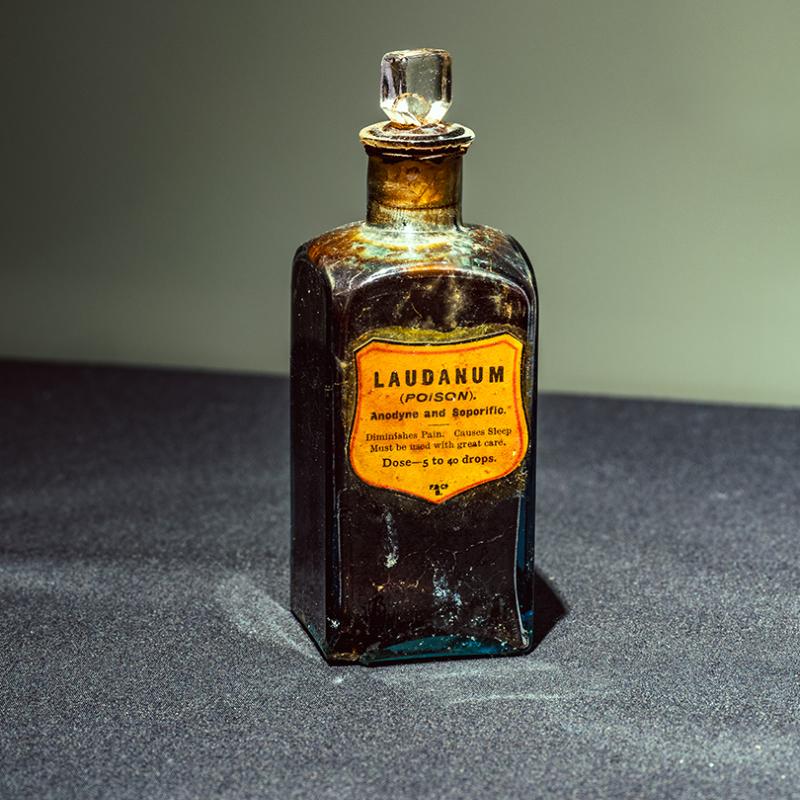 An old glass bottle with stopper. The label reads Laudanum.