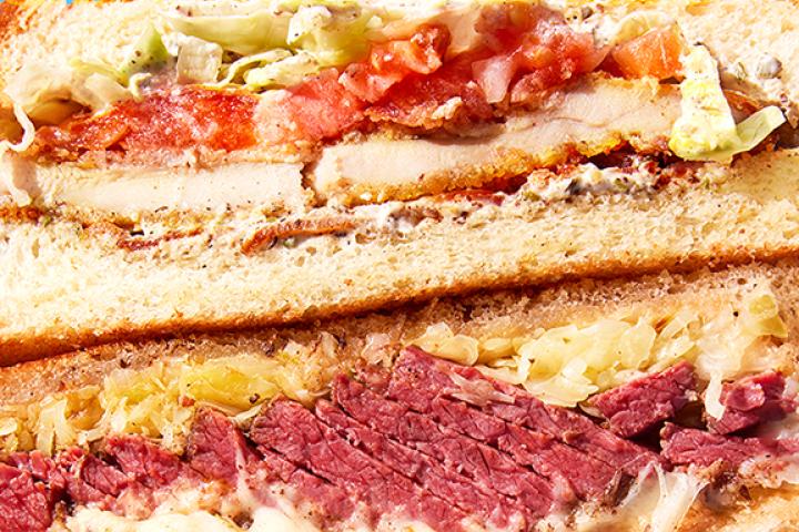 A stacked deli sandwich with multiple levels of ingredients.