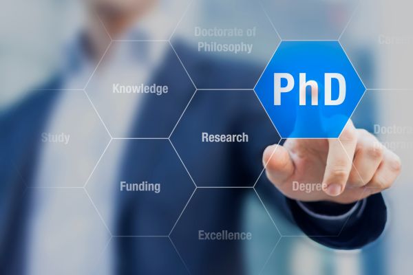 Man in a suit touching a button that says PhD