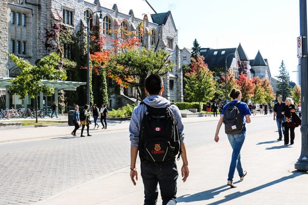 Students walking on the street at Queen's University in the Fall.