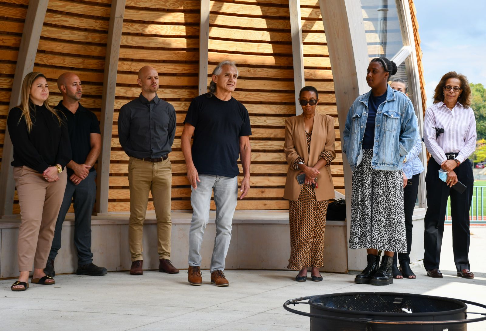 People gathered around a fire pit in the new Indigenous space at Queen's University.