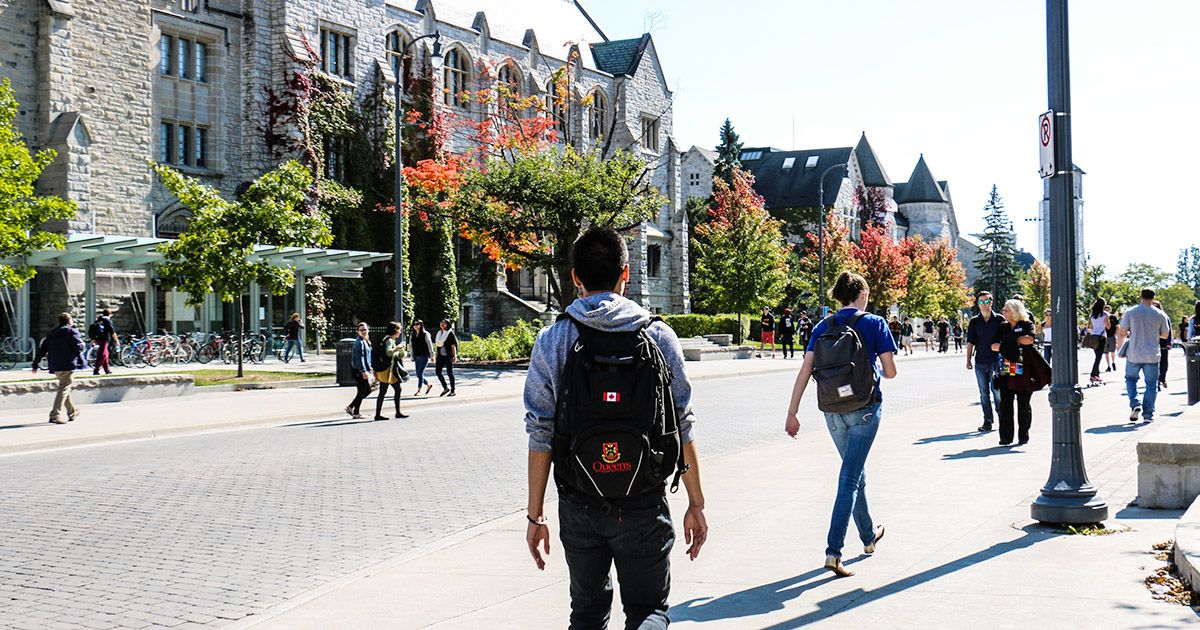 Students walking on the street at Queen's University in the Fall.