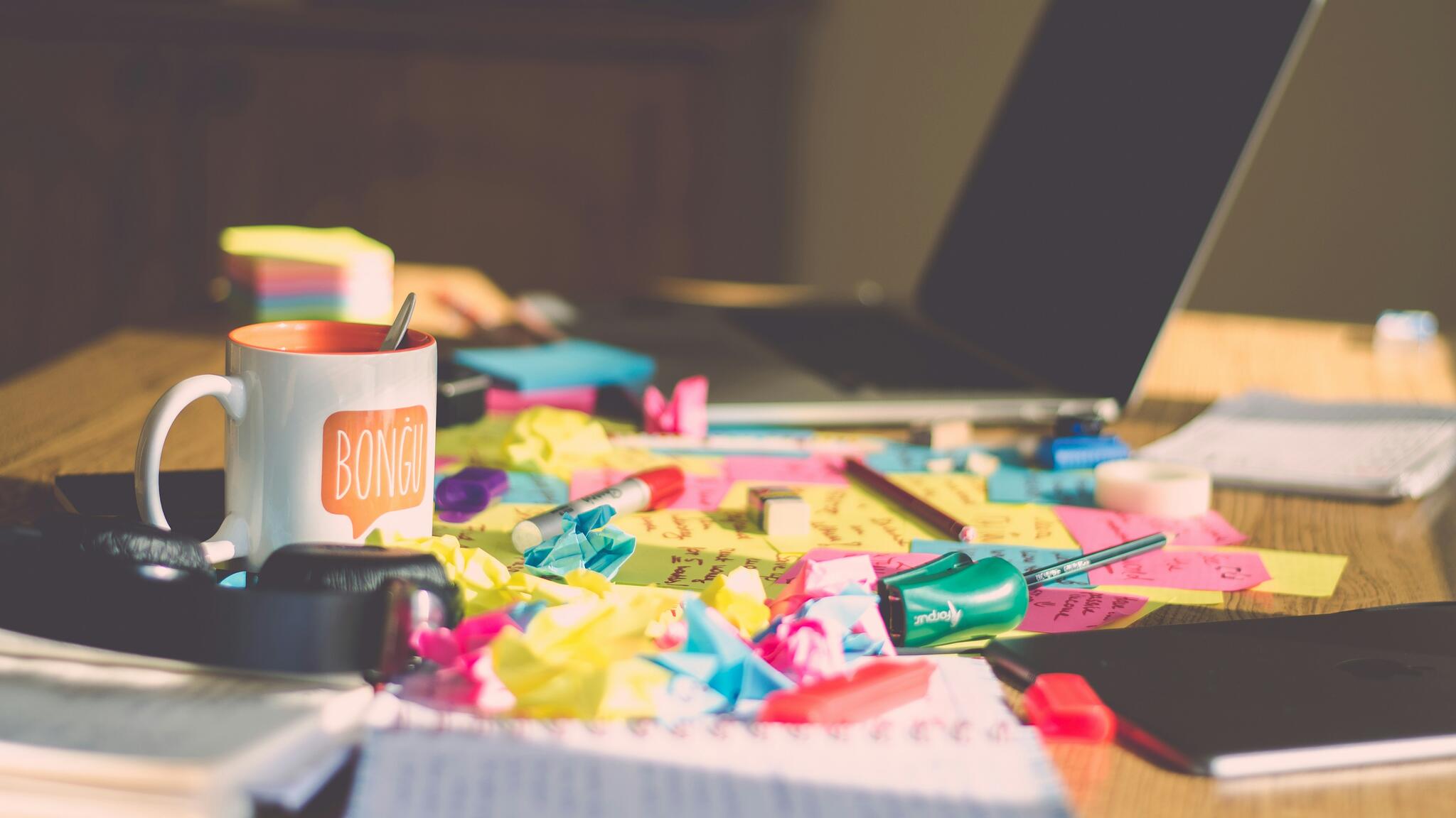 tabletop with papers and post it sprawled across it