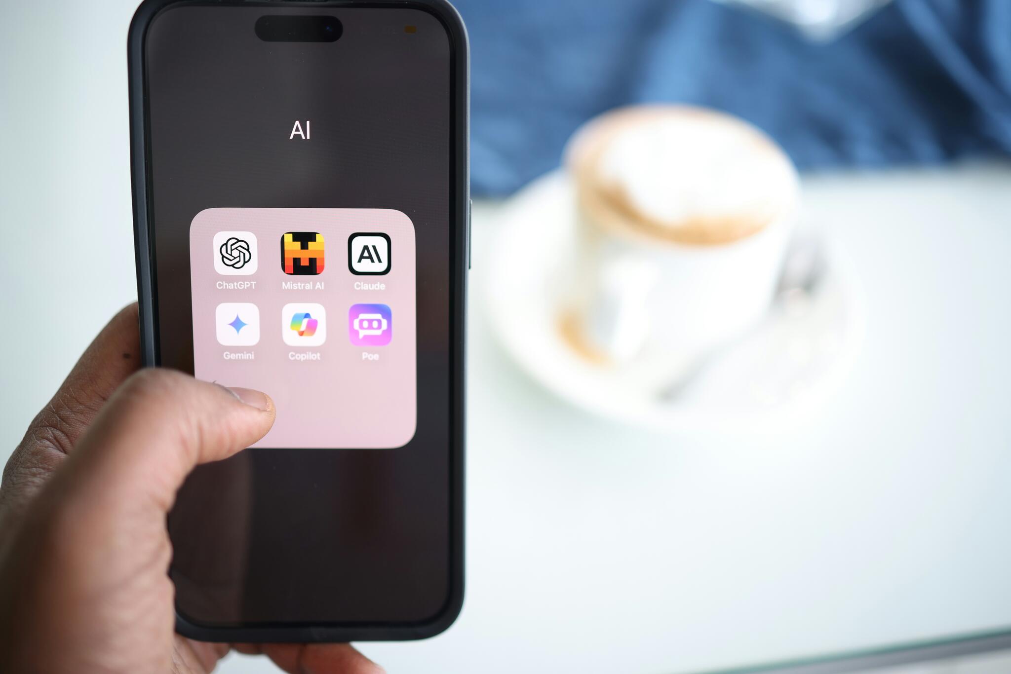 person holding up a phone with AI icons displayed