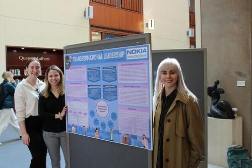 Students standing beside poster