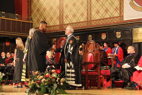 MIR grad walking across stage at ceremony