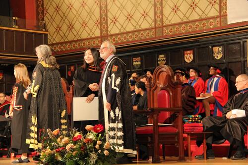 MIR grad walking across stage at ceremony