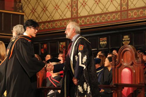 MIR grad walking across stage at ceremony