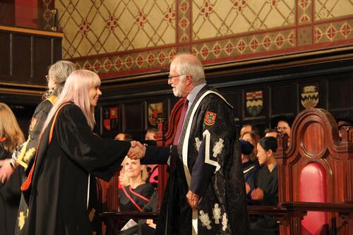 MIR grad walking across stage at ceremony