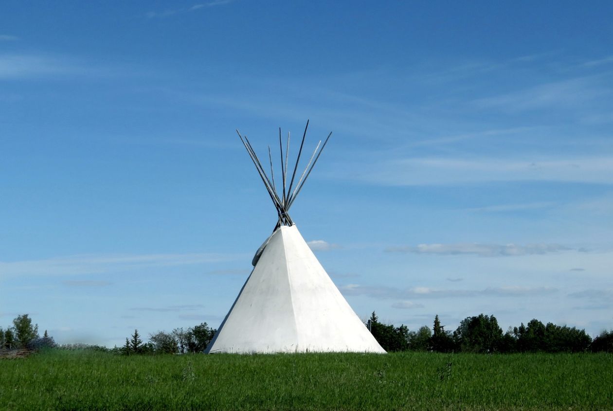 A picture of a white tipi outside