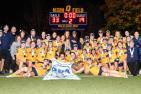 Queen's women's rugby team celebrate with the OUA banner