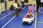A child goes for a ride in a toy electric vehicle 