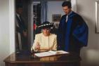 Princess Diana signs a book as Prince Charles looks on 