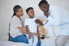 A doctor helping a young patient who is accompanied by a guardian. 