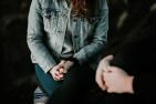 A woman in a jean jacket speaks with a counsellor.