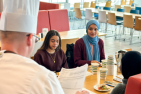Photograph of members of the Queen's University Muslim Student Association tasting from Hospitality Services' Ramadan menu.