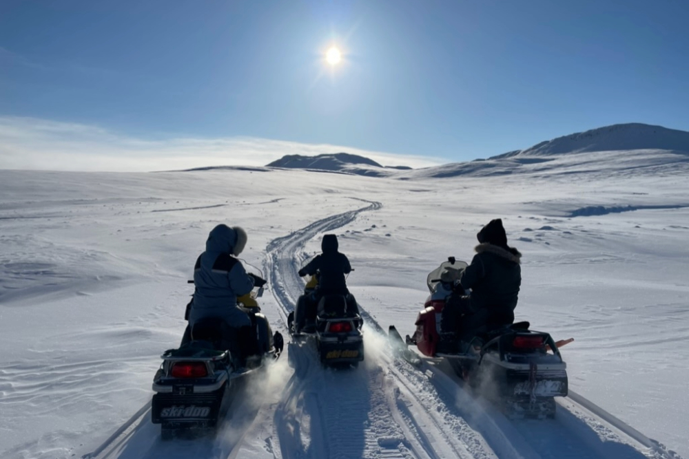 ICELab team on skidoos facing into setting syn.