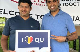 Students pose at the welcome booth in front of Gordon Hall on Queen's campus.