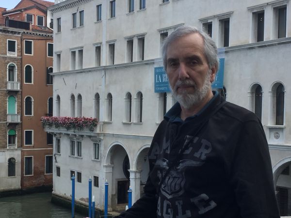 Image of James Cameron standing in front of a historic building with a camera