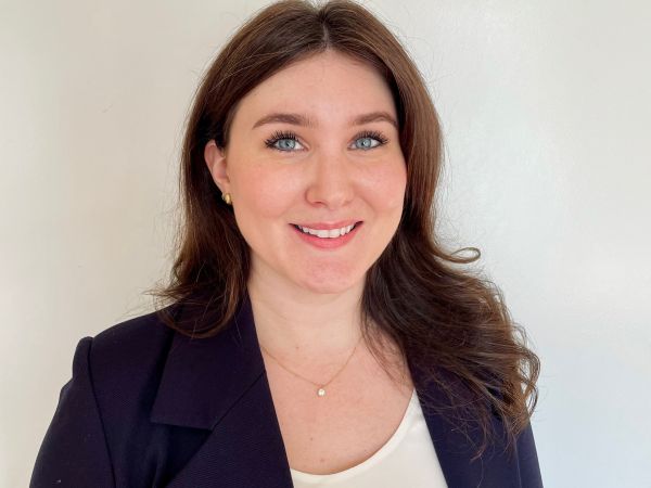 An image of a young woman with brown hair in a blazer 