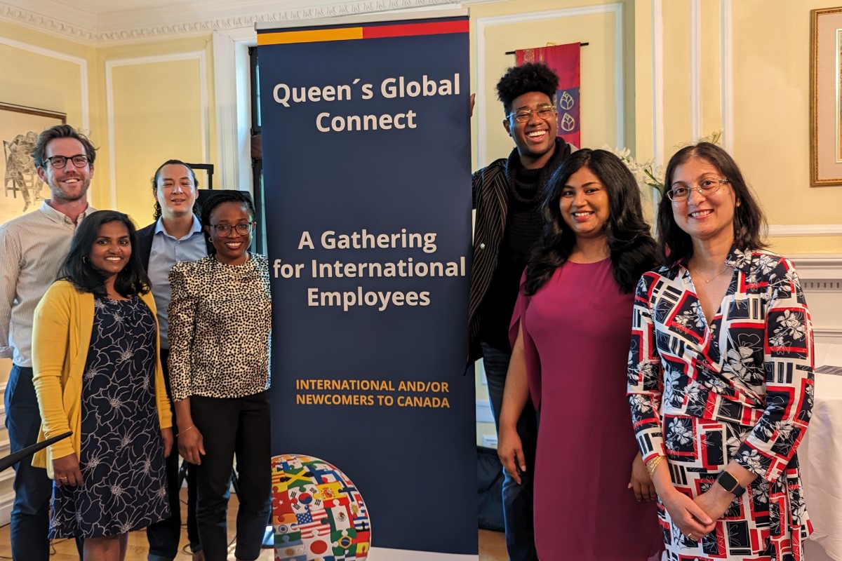 Photo of the Organizers of Queen's Global Connect standing by a banner