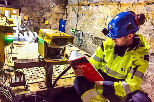 Man underground on a truck reading a book.
